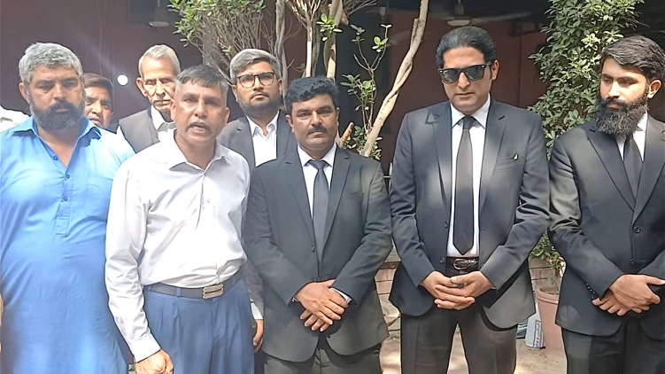Shahbaz Masih (L), rights activist Safdar Choudhry (in blue pants) and legal team for Maria Shahbaz’s family outside the Lahore High Court on Oct. 1, 2026.