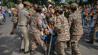Police officers detain a protester during a demonstration on October 10, 2026 in New Delhi, India.