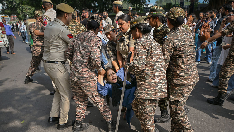 Police officers detain a protester during a demonstration on October 10, 2026 in New Delhi, India.
