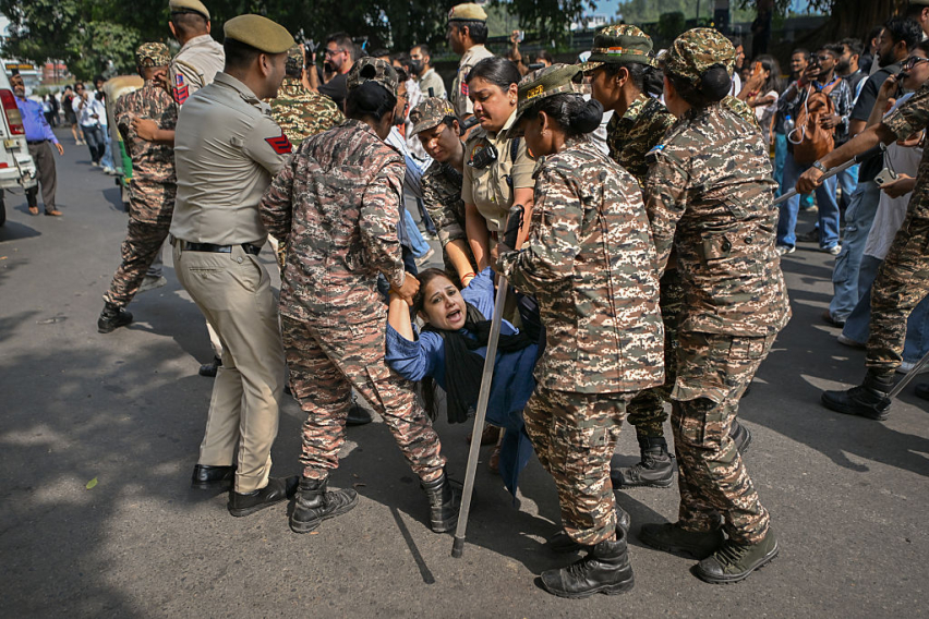Police officers detain a protester during a demonstration on October 10, 2026 in New Delhi, India.
