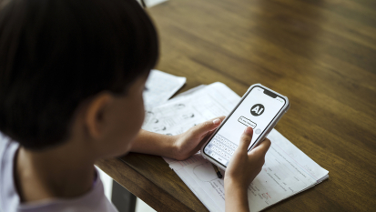 A child uses an artificial intelligence chatbot on a smartphone while doing homework.